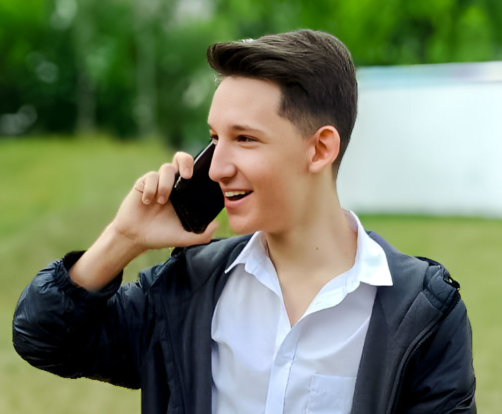 Julian sieht man im Drei-Viertel-Profil, wie er telefoniert, mit lachendem Blick.