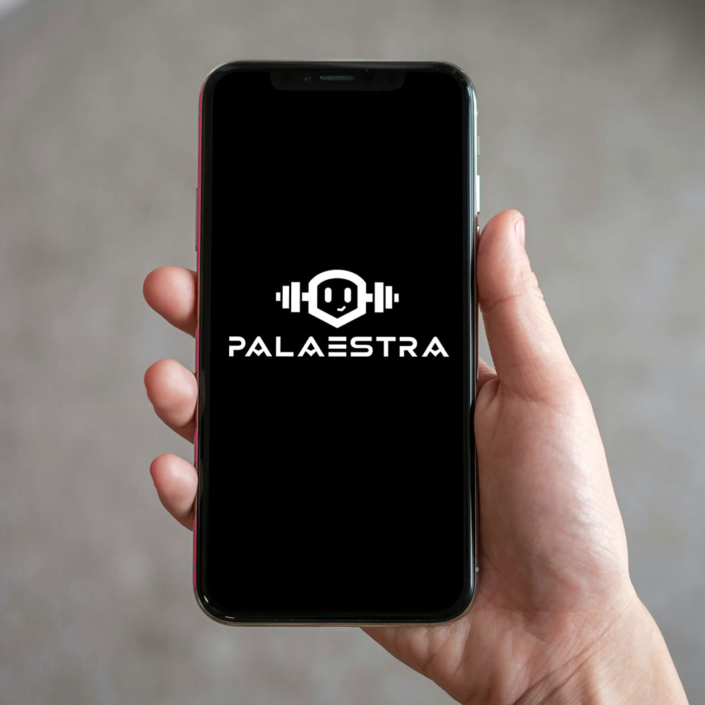 Ein Handy-Mockup mit einem Kombiniertesm Logo. Das Wortzeichen sagt Palaestra, das Bildzeichen ist darüber mit einem Roboter-Mascoutchen Logo, welches Hantel Ohren hat.