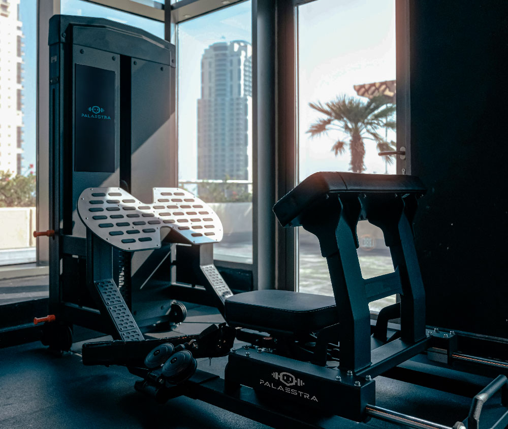 EIne Fitnessmaschine wie sie im Fitnesstudio aussehn könnte mit einem Monitor dran. Darauf ist das Kombinierte Logo so wie an der seite der Maschine. IMG by: https://unsplash.com/de/fotos/ein-fitnessraum-mit-laufband-und-fenster-OrKpiT0zRGQ